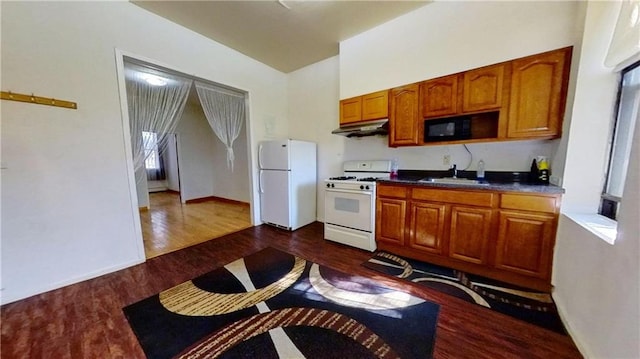 kitchen with sink, white appliances, and dark hardwood / wood-style floors