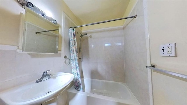 bathroom featuring sink, tile walls, backsplash, and shower / tub combo with curtain