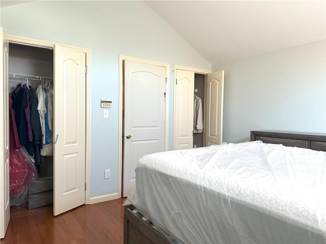 bedroom with lofted ceiling, a closet, and dark wood-style flooring