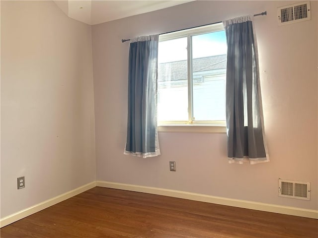 unfurnished room with visible vents, baseboards, and wood finished floors