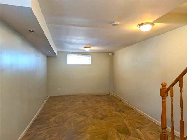 below grade area featuring stairway, baseboards, and visible vents