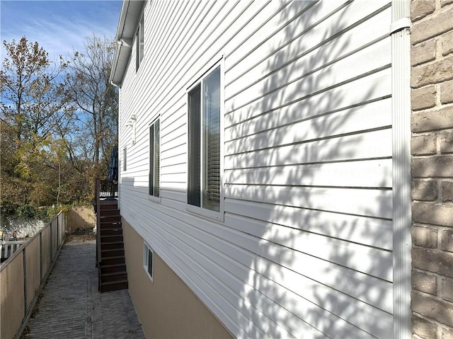 view of side of property with stairway and fence