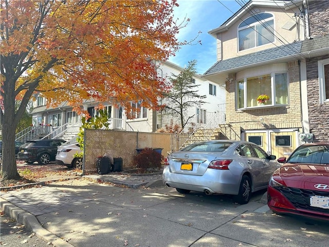 exterior space with stairway and roof with shingles