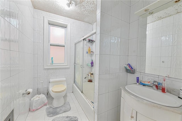 bathroom with walk in shower, toilet, tile walls, vanity, and tile patterned flooring