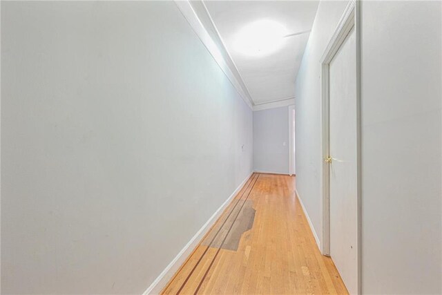 corridor with crown molding and light hardwood / wood-style flooring