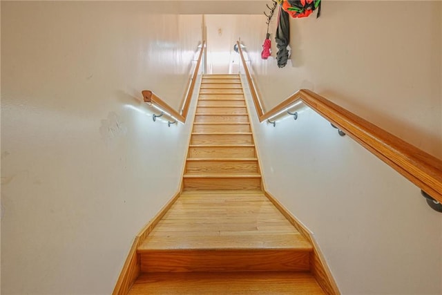 stairs with wood finished floors and baseboards