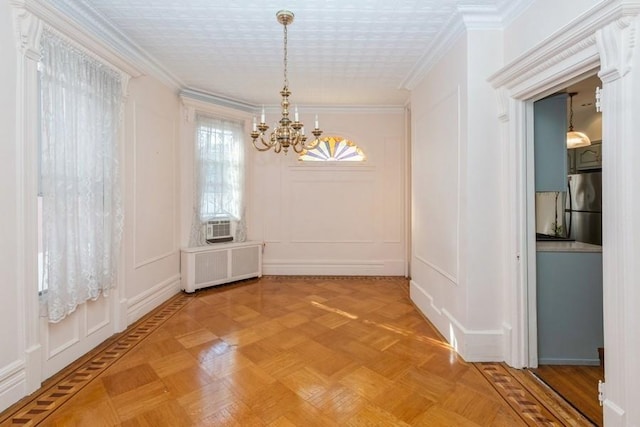 unfurnished dining area with parquet floors, crown molding, radiator, and a chandelier