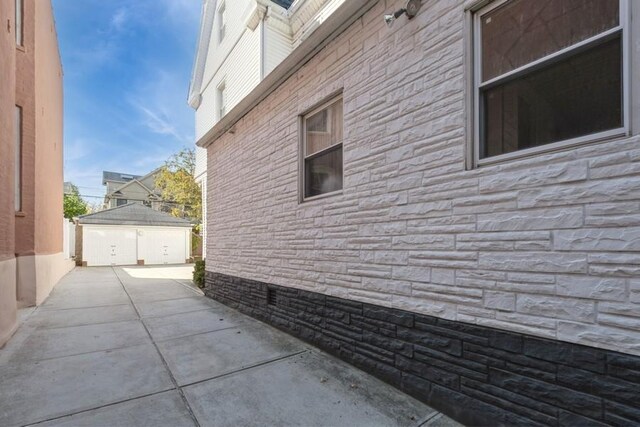 view of side of property with a patio and an outbuilding