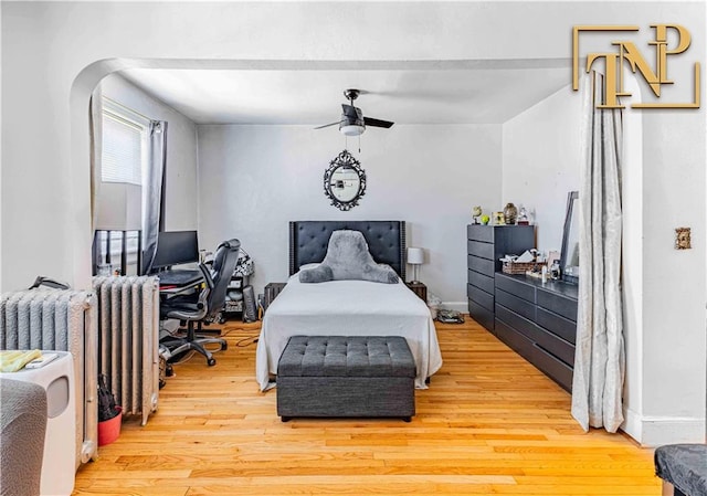 bedroom featuring radiator, light wood-type flooring, and ceiling fan