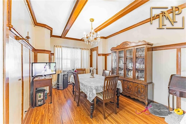 dining area featuring beam ceiling, crown molding, light hardwood / wood-style flooring, and an inviting chandelier