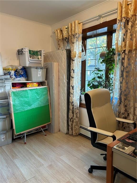 interior space featuring crown molding, a baseboard heating unit, and light wood-type flooring