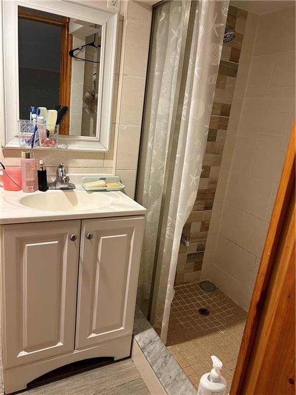 bathroom featuring a shower stall and vanity