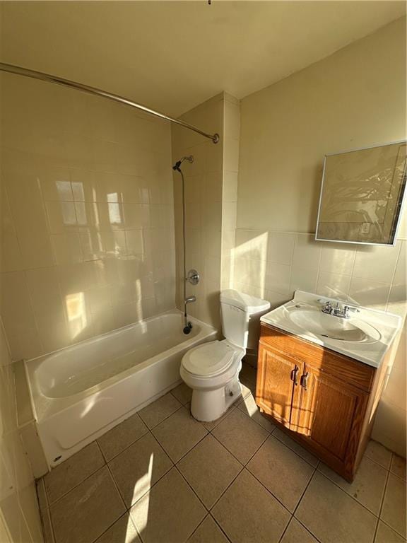 full bathroom featuring vanity, toilet, tiled shower / bath combo, and tile patterned flooring