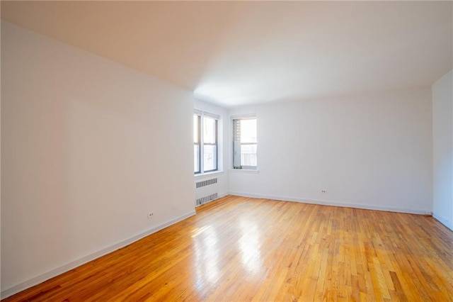 15 Oliver St Unit 4C, Brooklyn, NY 11209 - empty room with radiator heating unit, light wood-style floors, and baseboards