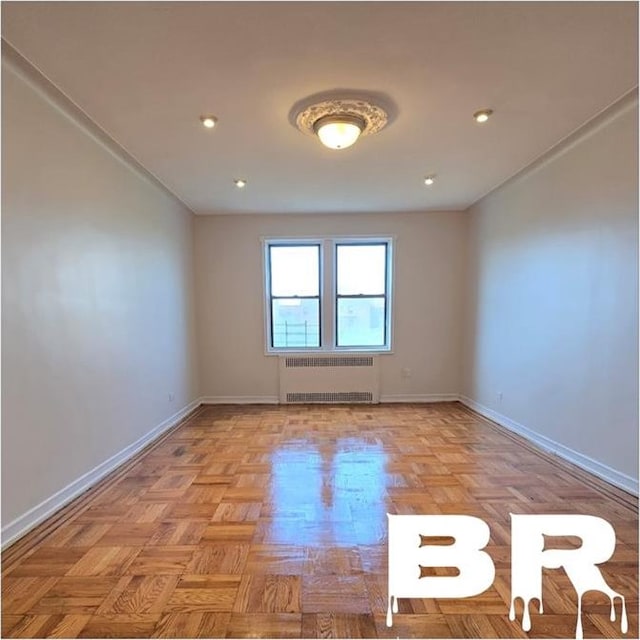 spare room featuring light parquet floors and radiator heating unit