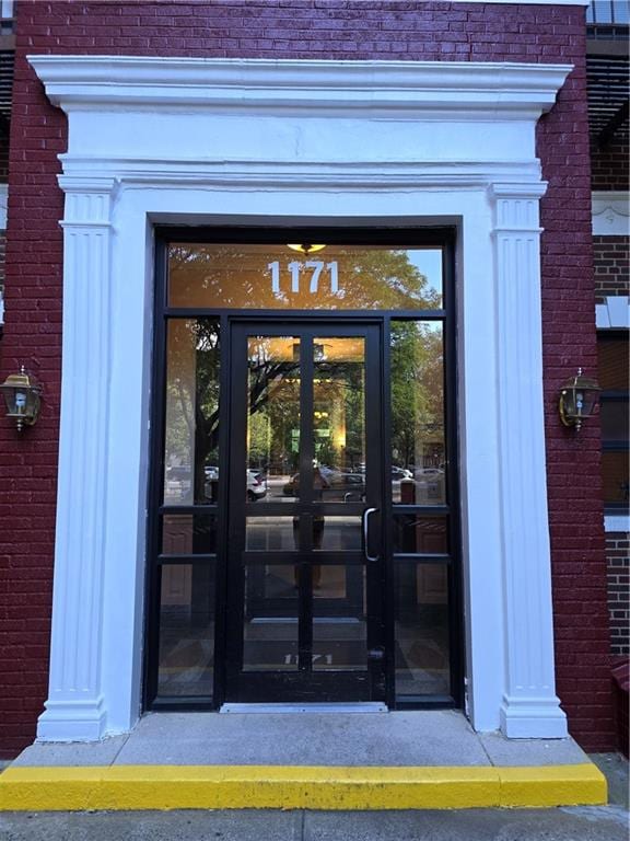 property entrance featuring french doors and brick siding