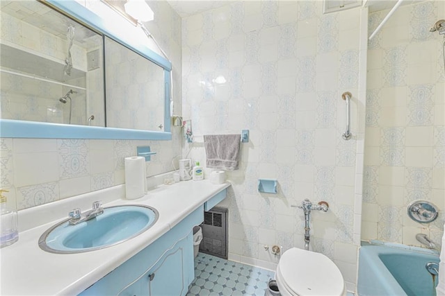 bathroom with toilet, visible vents, vanity, tile walls, and shower / washtub combination