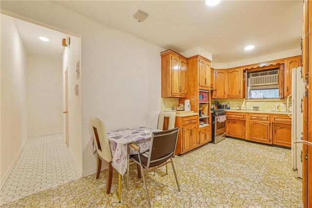 kitchen with appliances with stainless steel finishes, recessed lighting, brown cabinetry, and light countertops