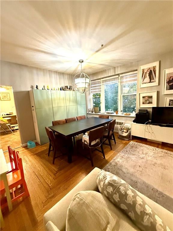 recreation room with wood finished floors and a notable chandelier