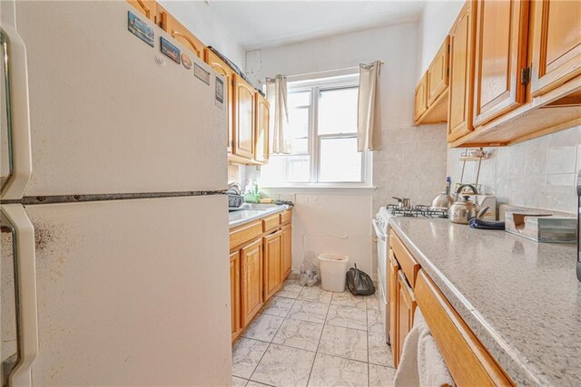 kitchen featuring backsplash and white appliances