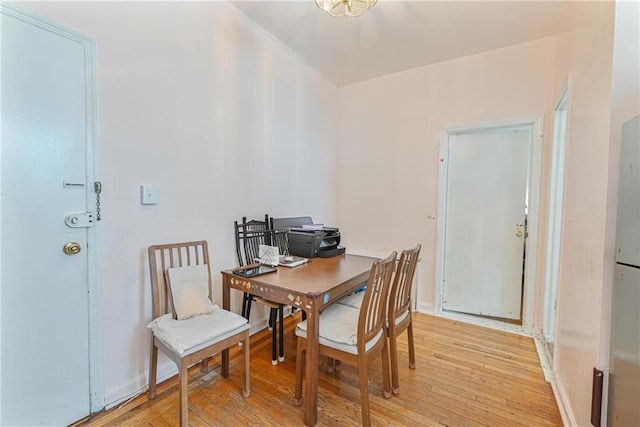 dining area with baseboards and light wood-style floors