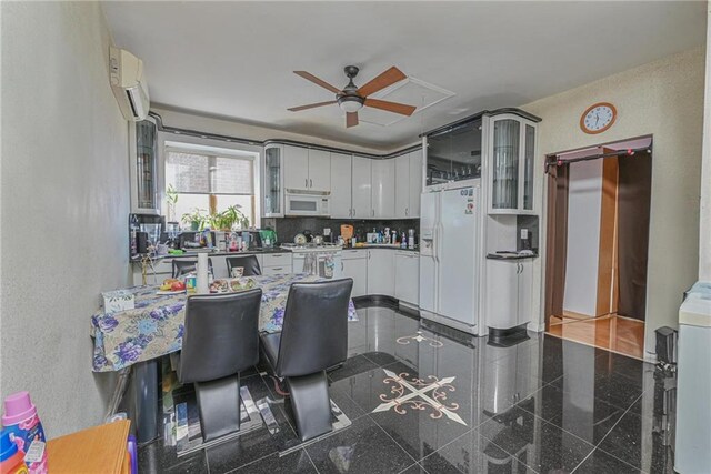 kitchen featuring white cabinetry, a wall mounted AC, backsplash, ceiling fan, and white appliances