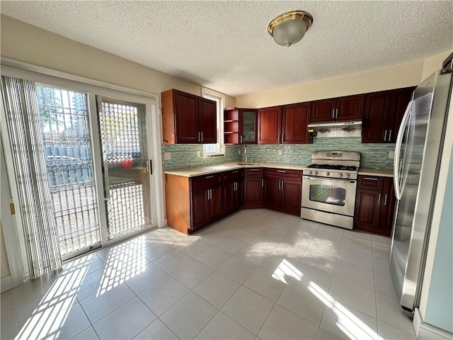 kitchen with sink, backsplash, stainless steel appliances, and light tile patterned flooring