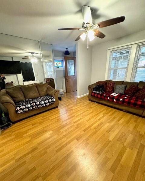 living room with light hardwood / wood-style floors and ceiling fan