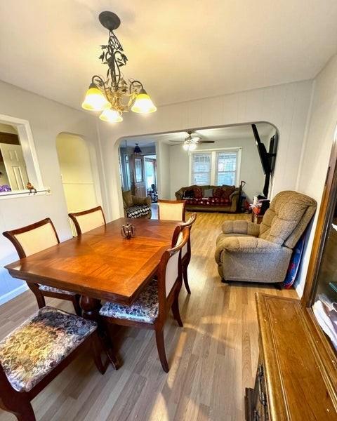 dining area featuring hardwood / wood-style floors and ceiling fan with notable chandelier