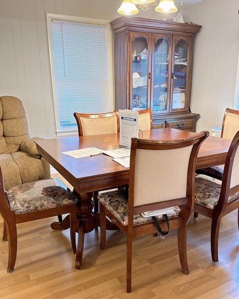 dining area with wooden walls, a notable chandelier, and light wood-type flooring