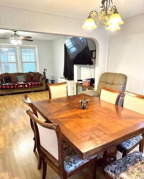 dining area featuring ceiling fan with notable chandelier and light wood-type flooring