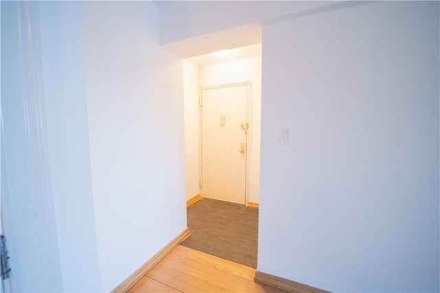 hallway featuring light wood-type flooring and baseboards