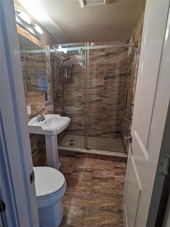 bathroom featuring a stall shower and toilet