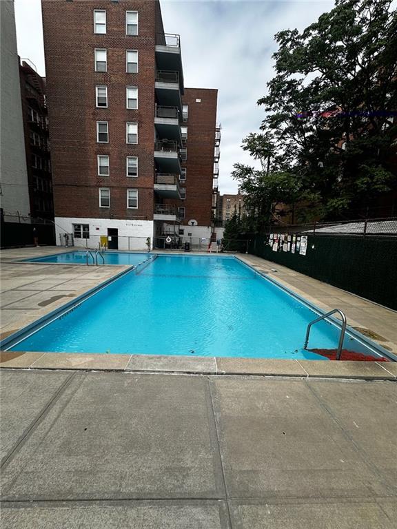 pool with a patio area and fence