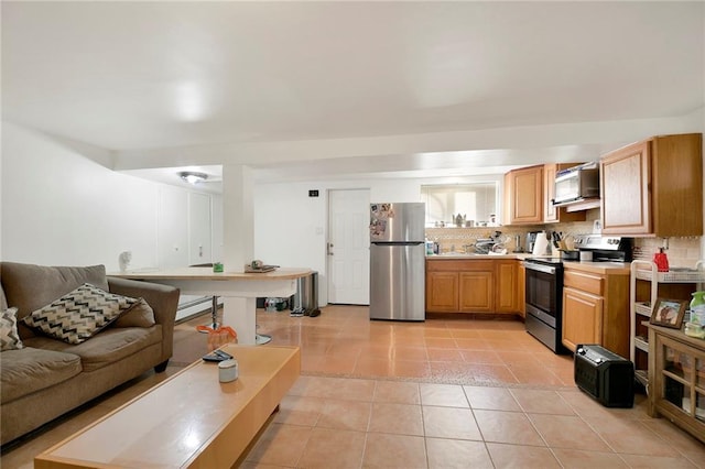 kitchen featuring appliances with stainless steel finishes, decorative backsplash, and light tile patterned floors