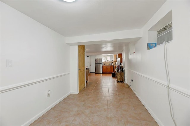 hall with a wall unit AC and light tile patterned floors