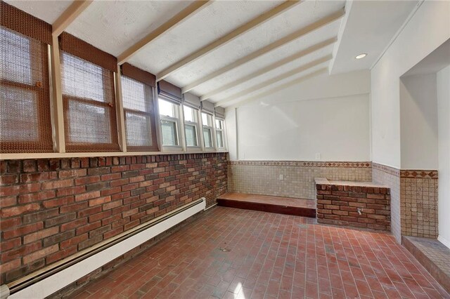 interior space with tile walls, brick wall, and baseboard heating