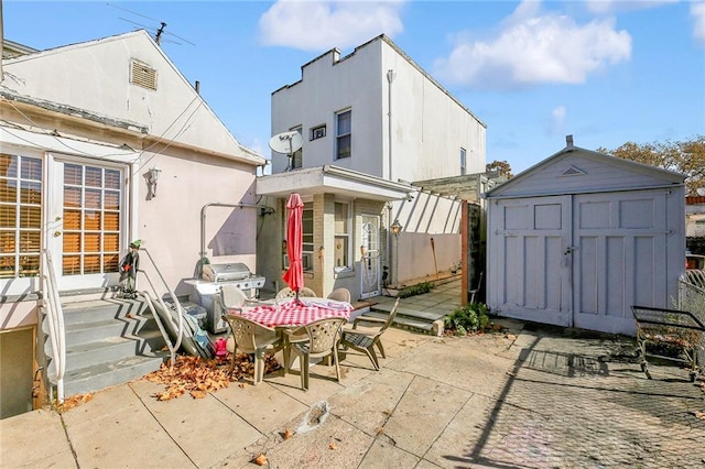 back of house with a patio area and a storage unit