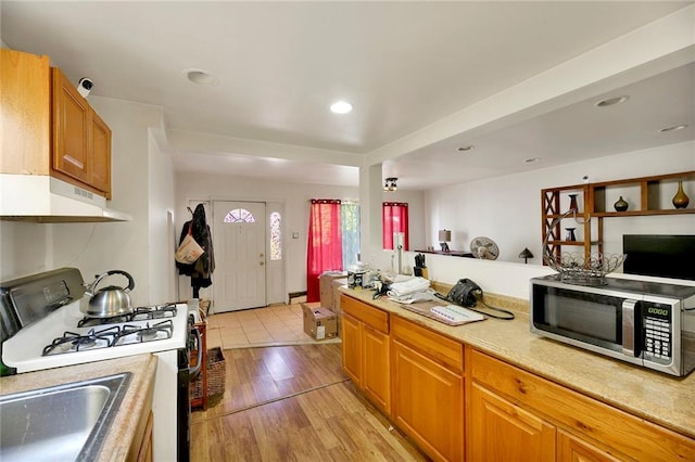 kitchen with light hardwood / wood-style flooring, sink, and range with gas cooktop