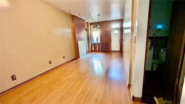 interior space featuring radiator heating unit and light hardwood / wood-style flooring