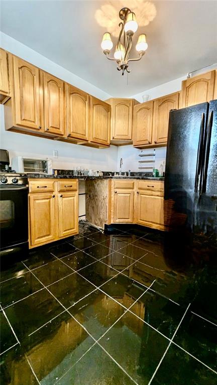 kitchen featuring black appliances, sink, and an inviting chandelier