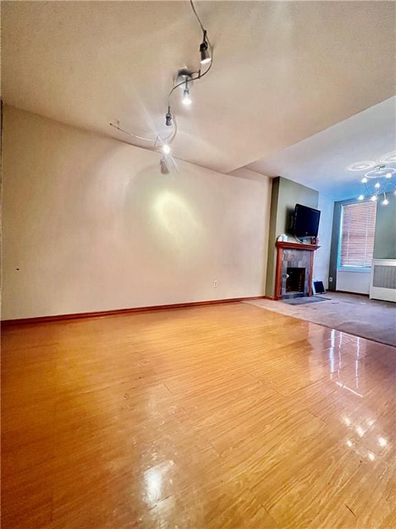 unfurnished living room with wood-type flooring and radiator heating unit