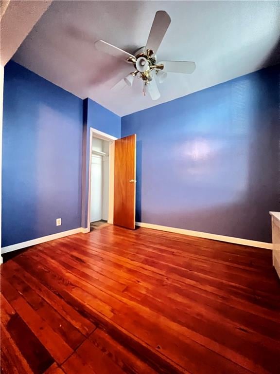 empty room with ceiling fan and wood-type flooring