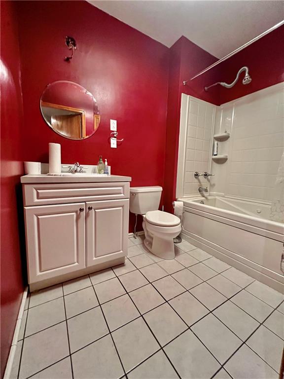 full bathroom with tile patterned floors, toilet, vanity, and tiled shower / bath