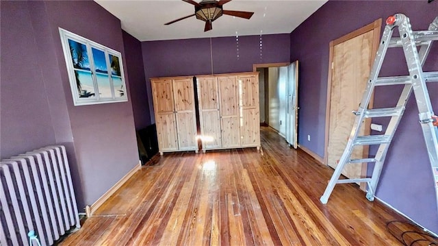 unfurnished bedroom featuring radiator and hardwood / wood-style floors