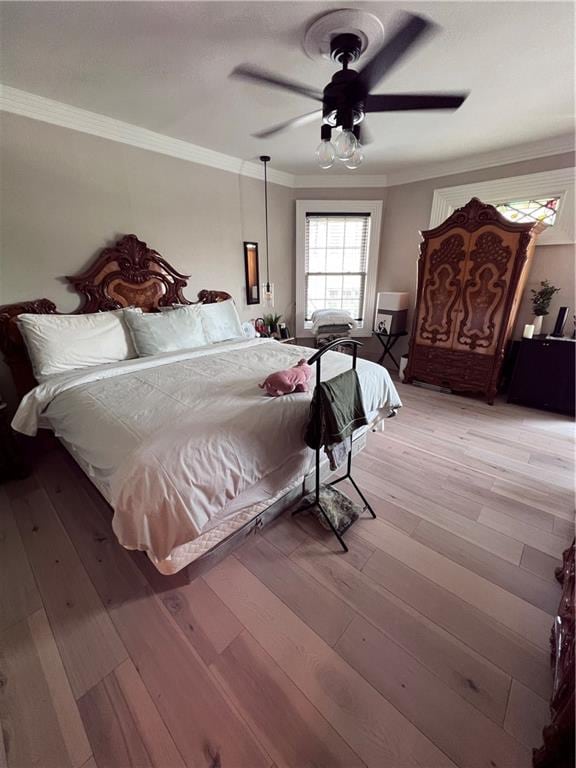 bedroom featuring ornamental molding, hardwood / wood-style floors, and ceiling fan