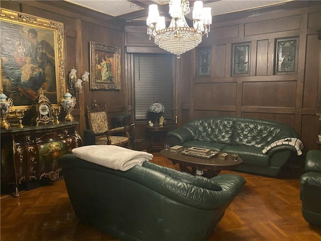 living room featuring a textured ceiling, dark parquet floors, wooden walls, crown molding, and an inviting chandelier