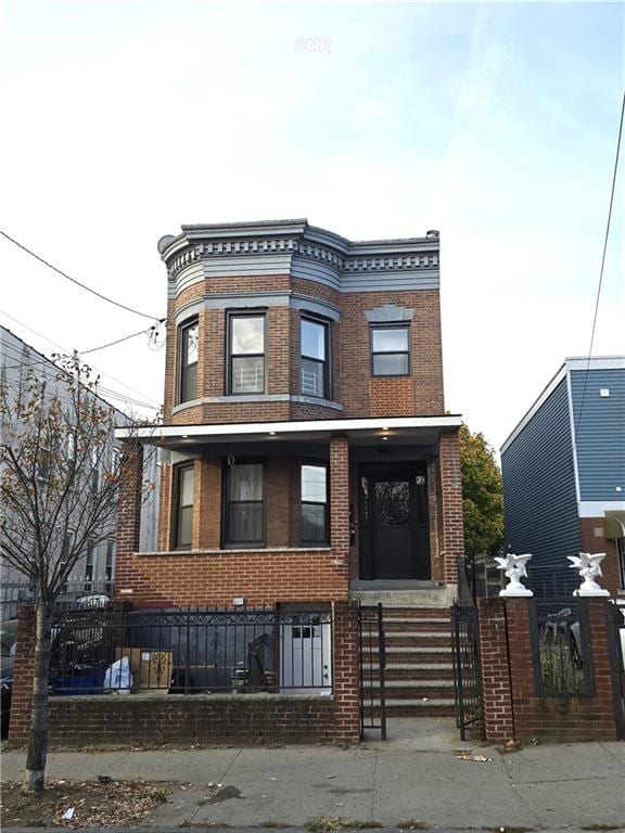 view of front facade with a fenced front yard and brick siding