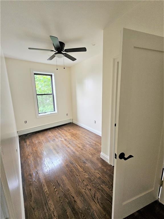 unfurnished room with baseboards, a baseboard heating unit, ceiling fan, and wood finished floors