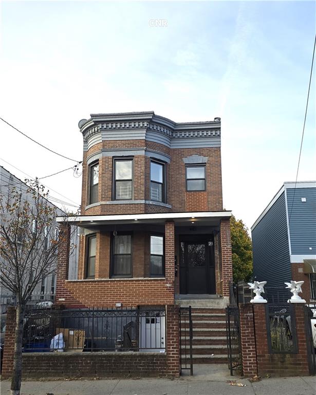 view of front of home with a fenced front yard and brick siding